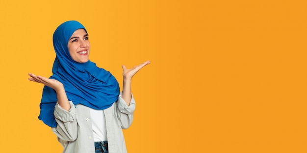 Photo gratuite portrait de jeune femme musulmane isolée sur fond de studio jaune