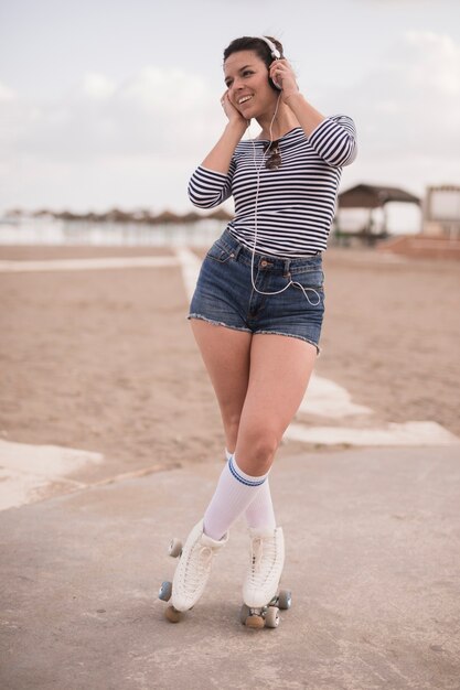 Portrait, de, a, jeune femme, patineur, écoute, musique, sur, casque, à, plage