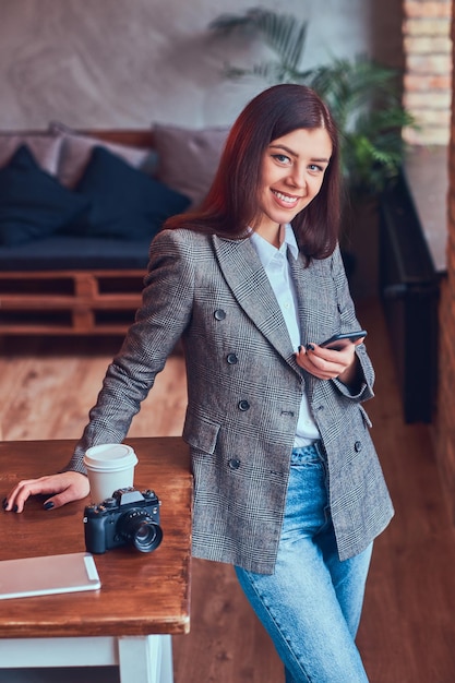 Portrait d'une jeune femme photographe travaille avec un téléphone leani