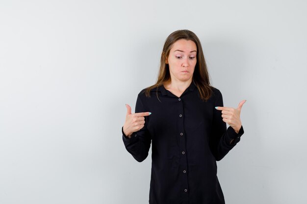 Portrait de jeune femme pointant sur elle-même et à la perplexité