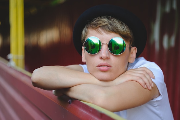 Portrait de jeune femme portant un chapeau élégant et des lunettes rondes