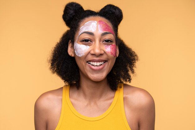 Portrait d'une jeune femme portant une crème hydratante et un masque facial