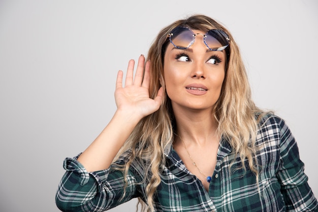 Portrait de jeune femme posant avec des lunettes élégantes.