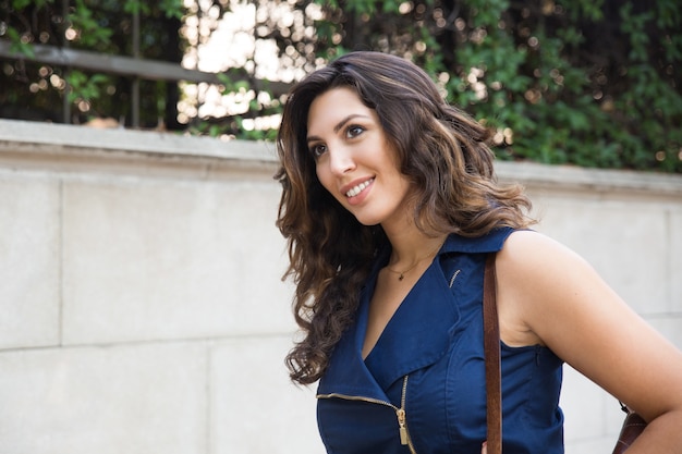 Portrait de jeune femme positive marchant dans la rue