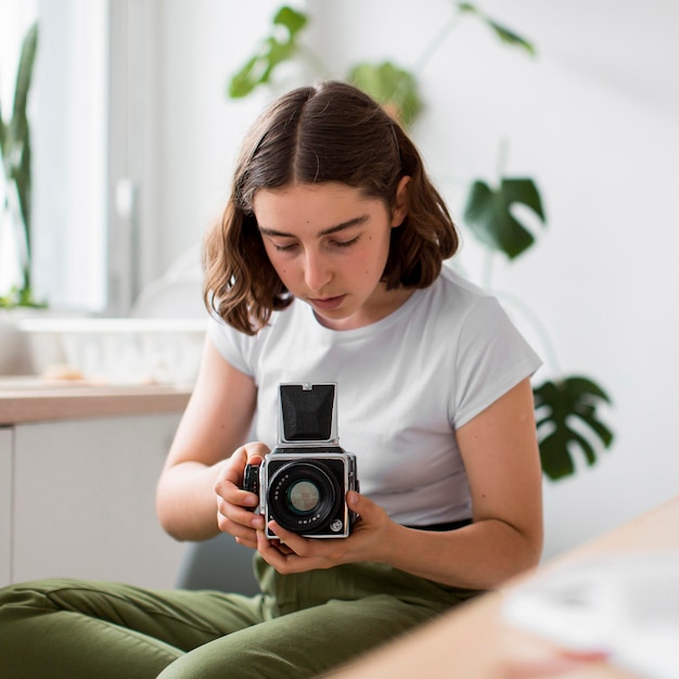 Portrait de jeune femme prenant une photo avec appareil photo