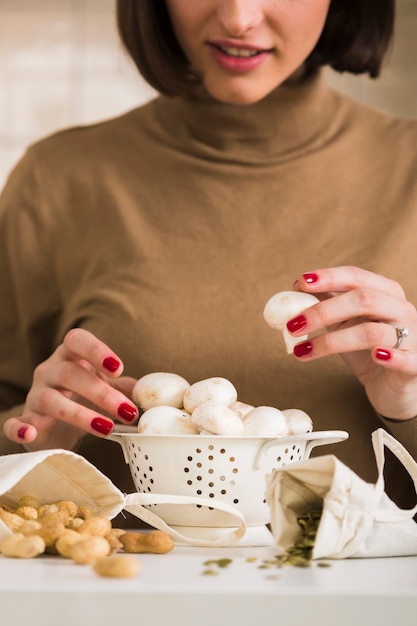 Photo gratuite portrait de jeune femme préparant des champignons