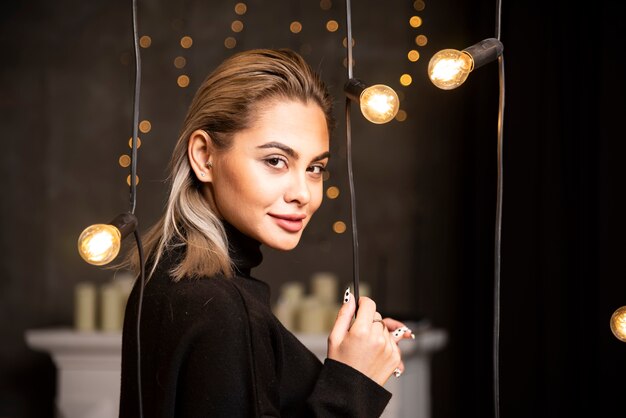 Portrait de jeune femme en pull noir debout et posant.