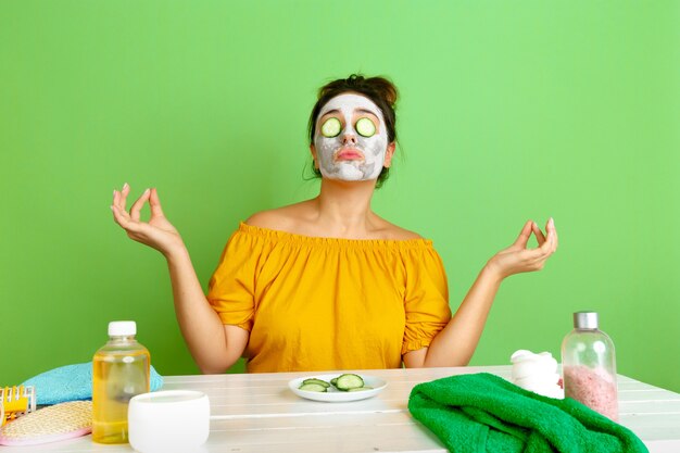 Portrait de jeune femme de race blanche dans sa routine de soins de jour, de peau et de cheveux de beauté. Modèle féminin avec des cosmétiques naturels appliquant un masque facial pour le maquillage. Soins du corps et du visage, concept de beauté naturelle.