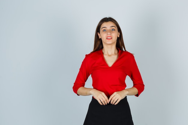 Portrait de jeune femme regardant la caméra en chemisier rouge