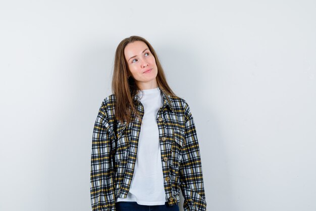 Portrait de jeune femme regardant en t-shirt, veste et à la vue de face réfléchie