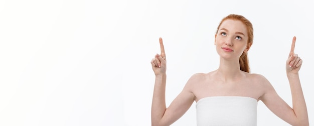 Photo gratuite portrait de jeune femme rousse avec une peau de rousseur parfaite montrant quelque chose d'intéressant à copier sp