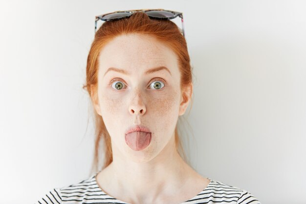 Portrait de jeune femme rousse portant des lunettes de soleil