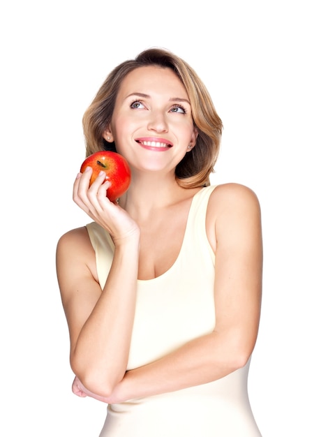 Portrait d'une jeune femme saine souriante avec pomme rouge isolé sur blanc.