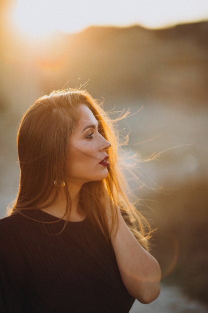 Portrait d'une jeune femme sensuelle sur un coucher de soleil