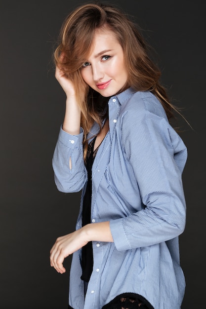 Portrait de jeune femme sensuelle souriante en chemise rayée
