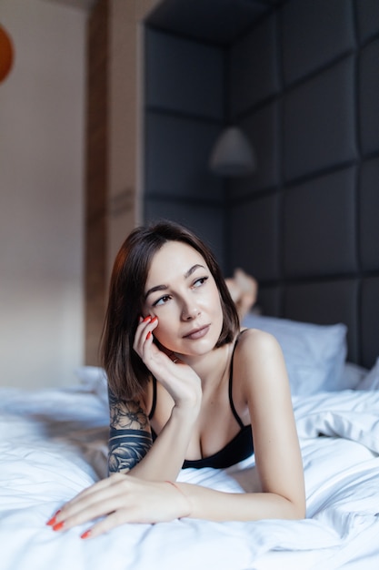 Portrait d'une jeune femme sexy au lit tôt le matin