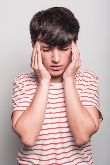 Photo gratuite portrait de jeune femme souffrant de maux de tête sur fond blanc