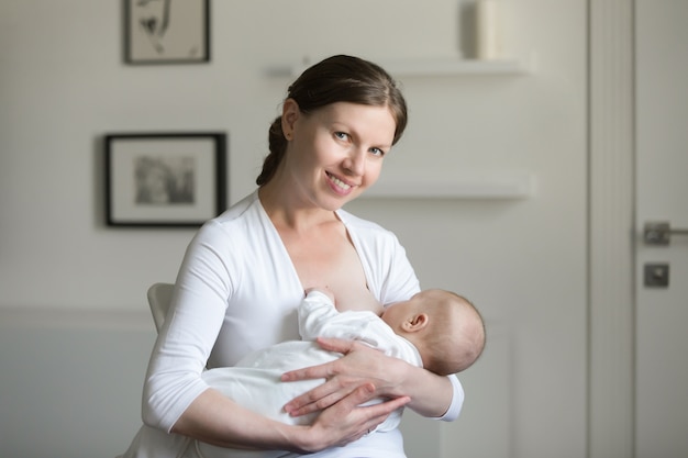 Portrait d&#39;une jeune femme souriante attrayante allaitant un chi