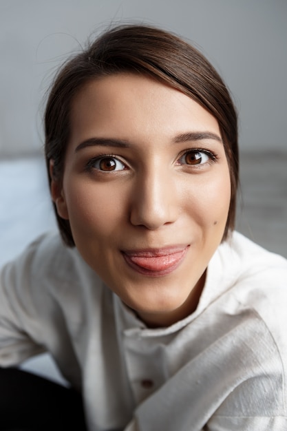 Portrait de jeune femme souriante montrant la langue