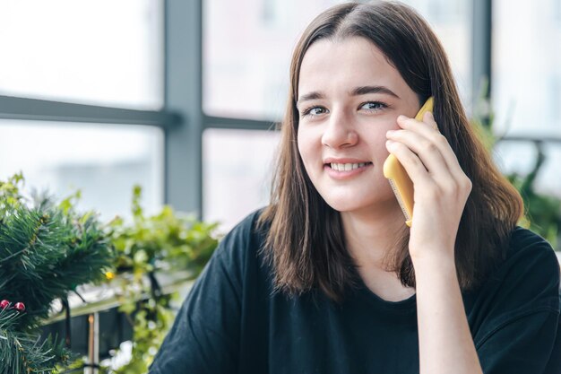 Portrait d'une jeune femme souriante parlant au téléphone