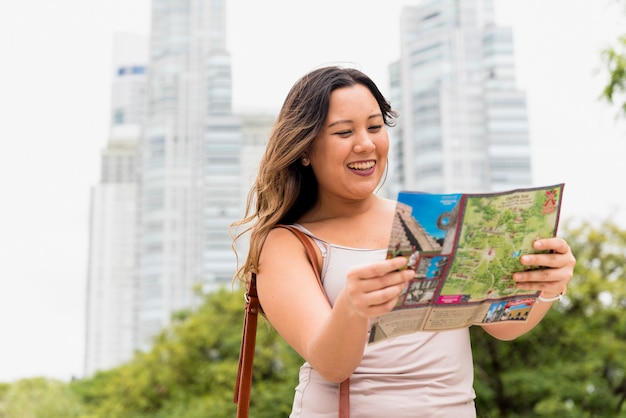 Portrait d&#39;une jeune femme souriante regardant un plan de la ville