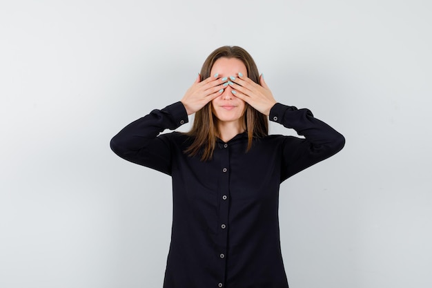 Portrait de jeune femme tenant les mains sur les yeux