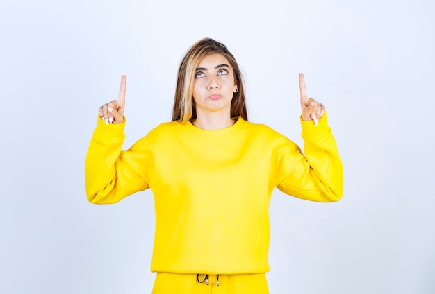 Portrait de jeune femme en tenue jaune se présentant à la caméra