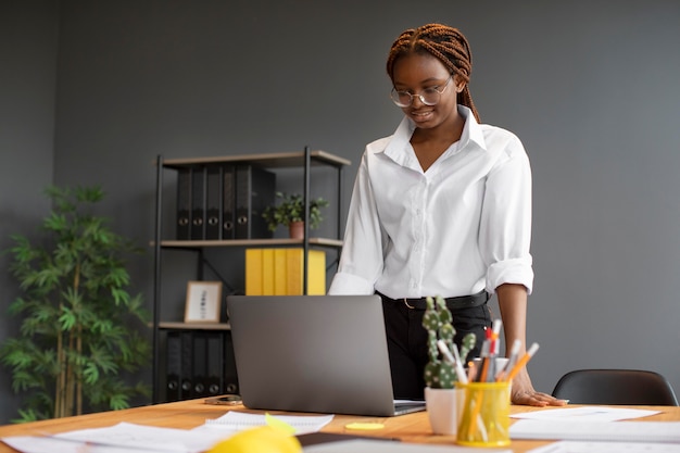 Photo gratuite portrait de jeune femme travaillant sur son ordinateur portable dans une entreprise en démarrage