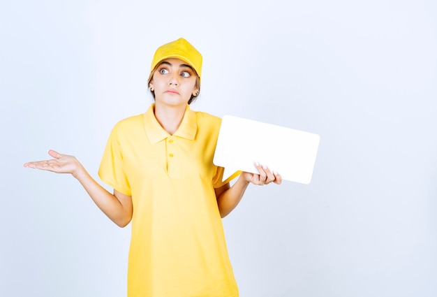 Portrait d'une jeune femme en uniforme jaune avec une bulle vide.