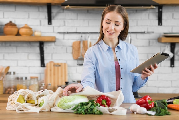 Photo gratuite portrait de jeune femme vérifiant l'épicerie biologique