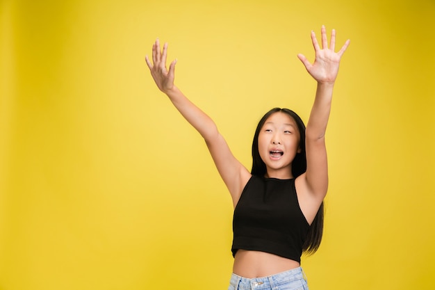 Portrait de jeune fille asiatique isolé sur jaune