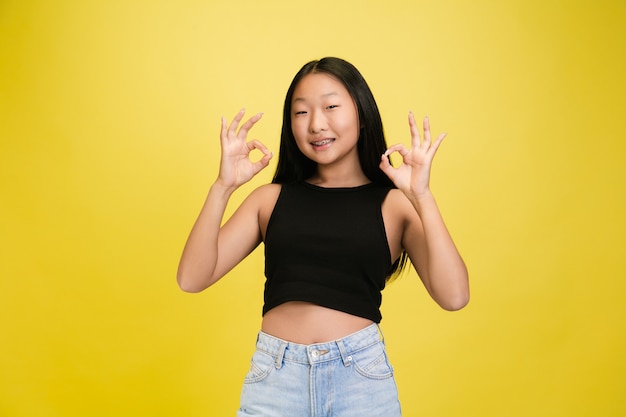 Portrait De Jeune Fille Asiatique Isolé Sur Jaune