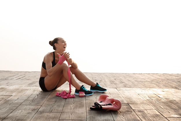 Portrait de jeune fille belle sportive se préparant à l'entraînement de boxe au bord de la mer.