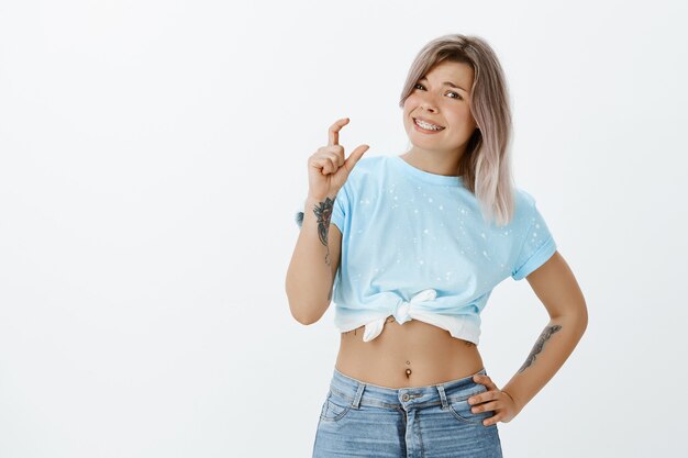 Portrait de jeune fille blonde mécontente qui pose en studio