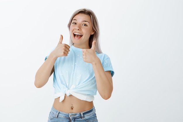 Portrait de jeune fille blonde positive posant dans le studio