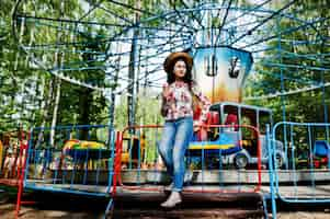 Photo gratuite portrait de jeune fille brune à lunettes roses et chapeau avec de la glace au parc d'attractions