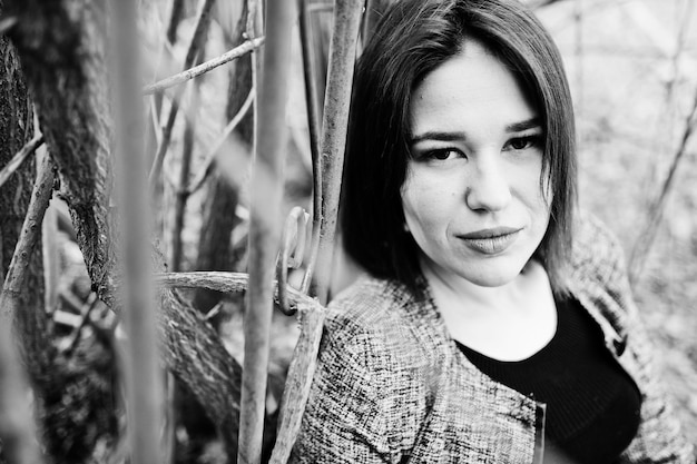 Portrait de jeune fille brune en robe noire au bois de printemps