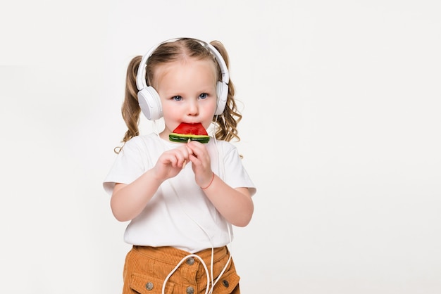 Portrait de jeune fille enfant dans le casque manger des bonbons