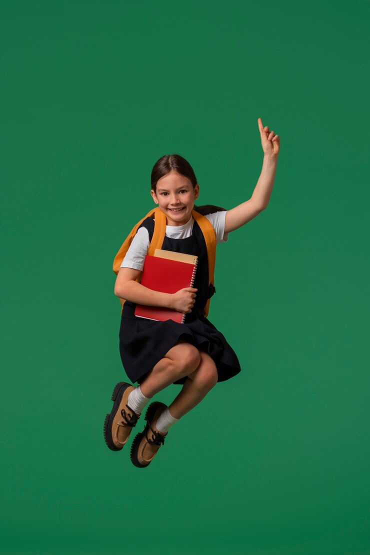 Photo gratuit portrait de jeune fille étudiante en uniforme scolaire sautant en l'air