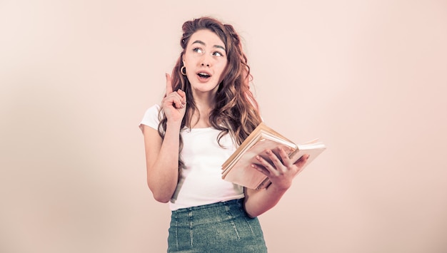 Portrait d'une jeune fille avec un livre sur un fond coloré