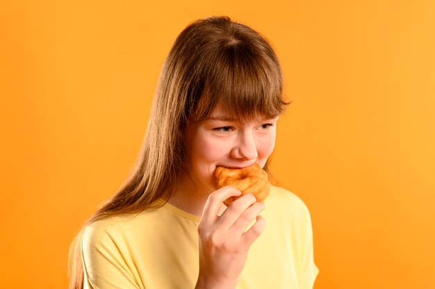 Portrait de jeune fille mangeant un beignet