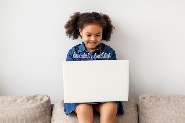 Portrait de jeune fille parcourant l'ordinateur portable à la maison