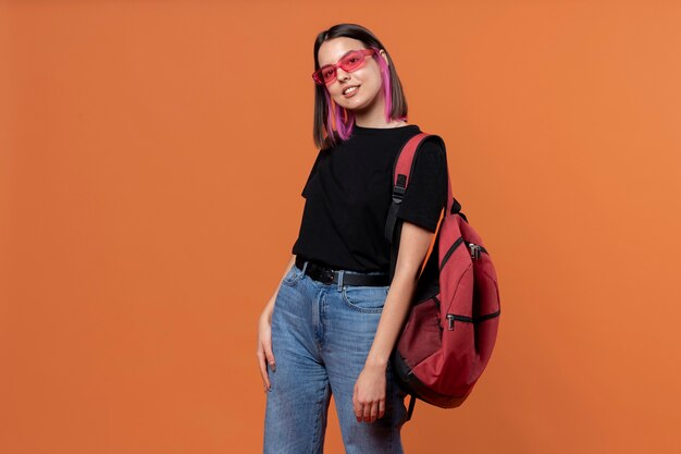 Portrait d'une jeune fille portant des lunettes de soleil et tenant son sac à dos