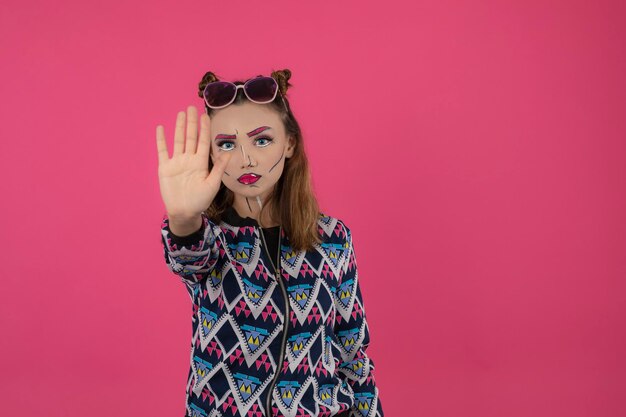 Portrait de jeune fille portant un maquillage fantaisie coloré et un arrêt de geste. Photo de haute qualité