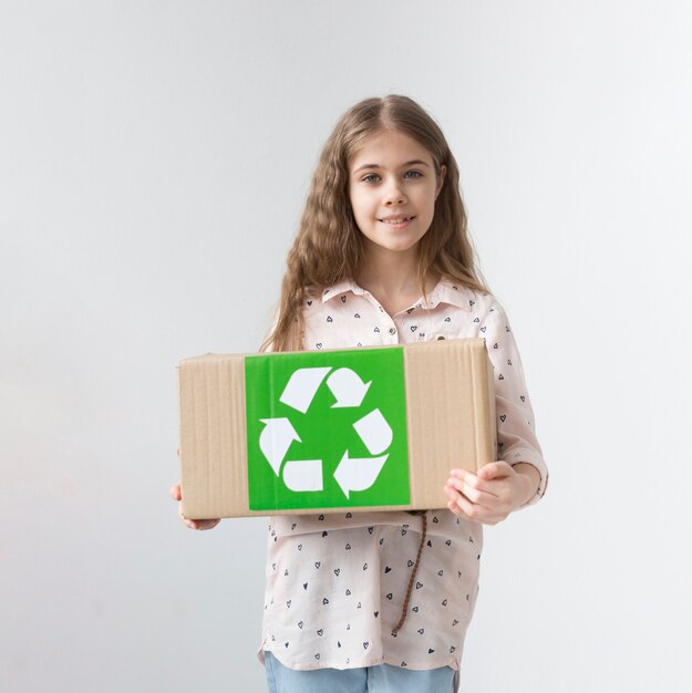 Portrait de jeune fille positive tenant la boîte de recyclage