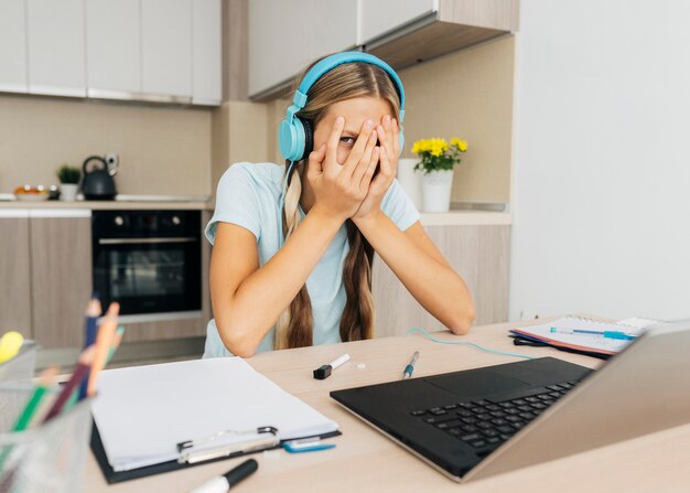 Portrait d'une jeune fille prêtant attention à la classe en ligne