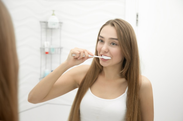 Portrait d&#39;une jeune fille qui nettoie ses dents