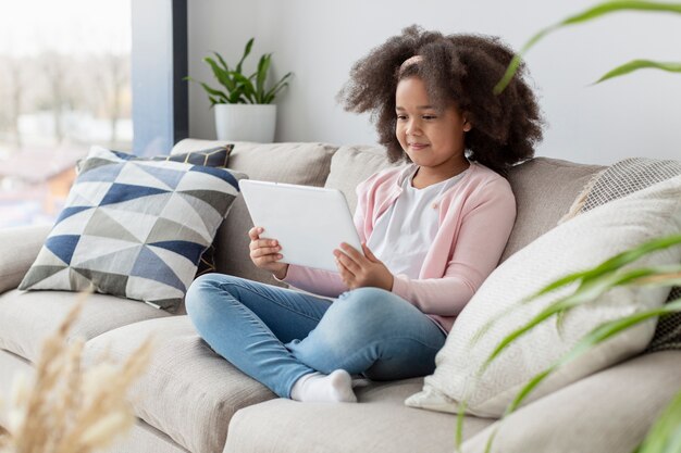 Portrait de jeune fille regardant des dessins animés sur le canapé