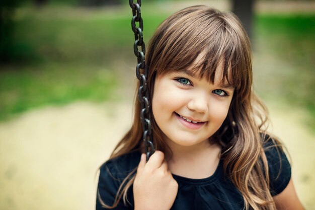 Portrait de jeune fille souriante sur la balançoire