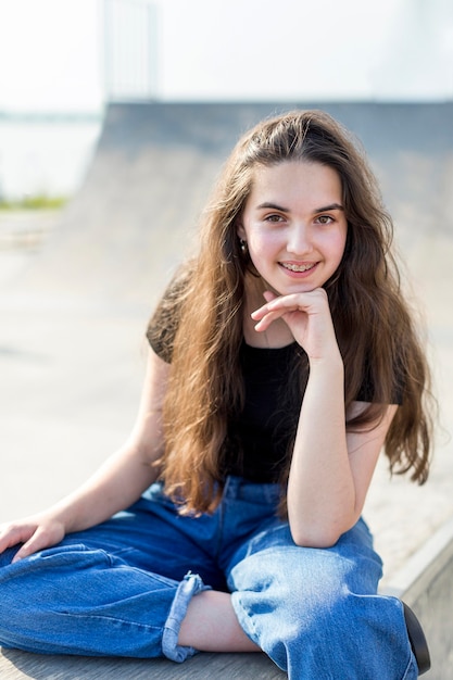 Portrait de jeune fille souriante posant à l'extérieur